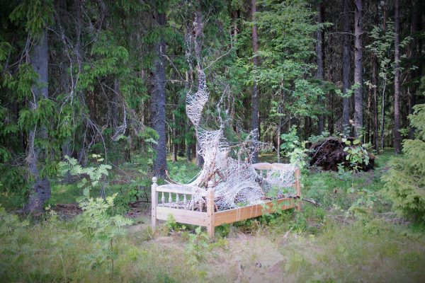 Konstverket "Sängen" ser ut som en säng som är utplacerad i en skog.