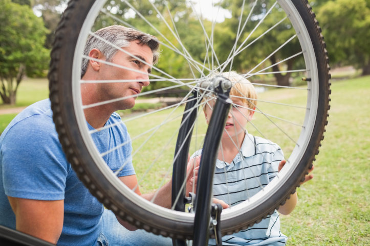 En pappa och son reparerar en cykel