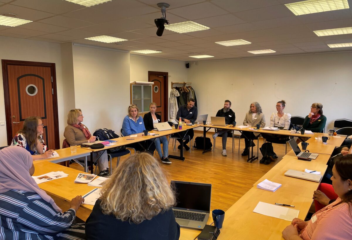 En grupp människor sitter i en konferenslokal.