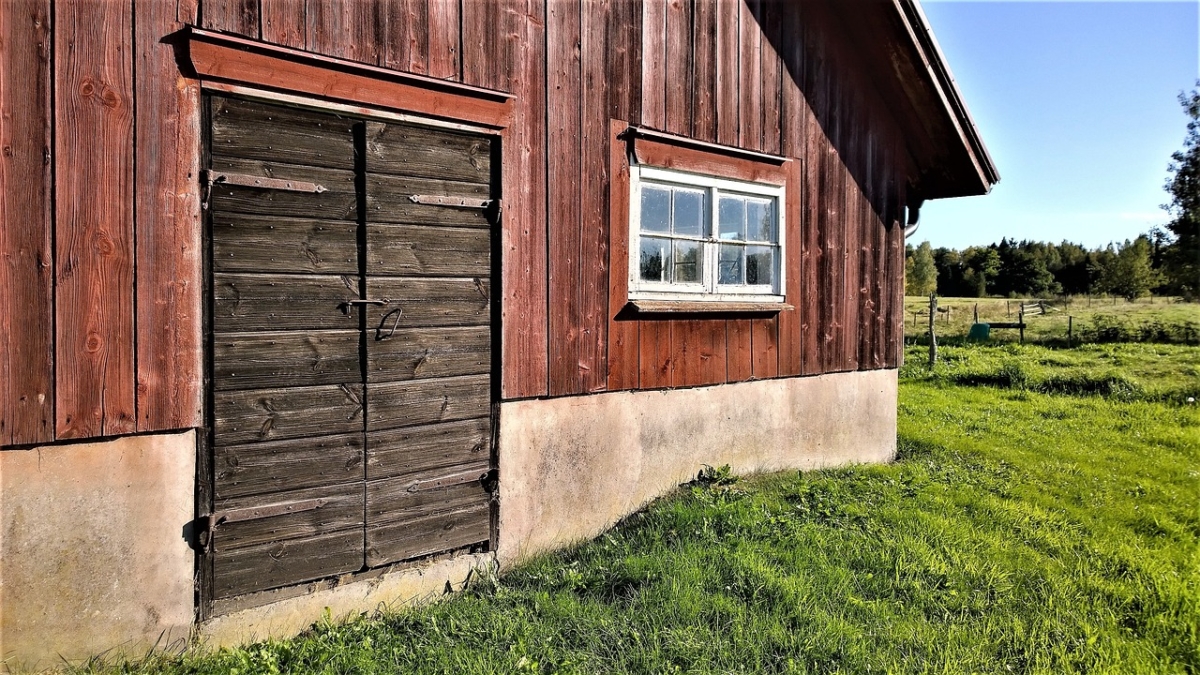 Äldre ladugård vid en åker.