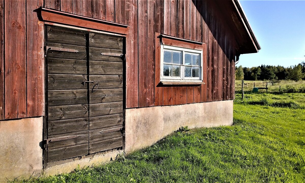 Äldre ladugård vid en åker.