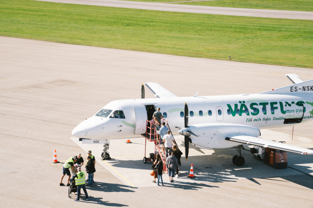 Passagerarflygplan där personer är på väg att gå ombord.