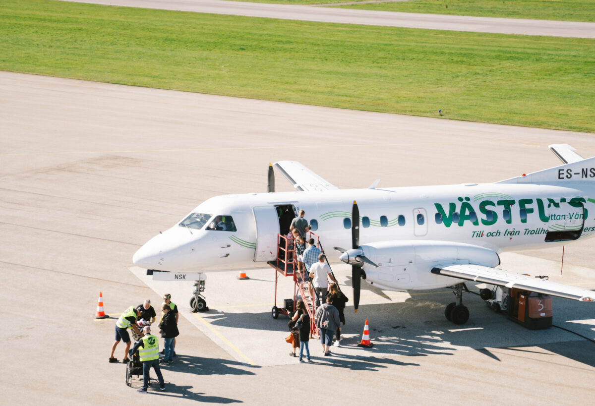 Passagerarflygplan där personer är på väg att gå ombord.