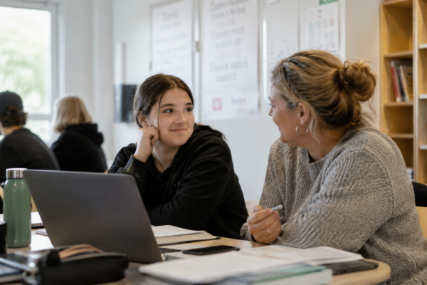 Ungdom och vuxen studerar vid dator