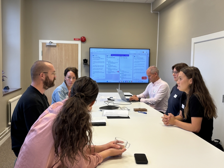 flera personer runt ett bord i diskussion