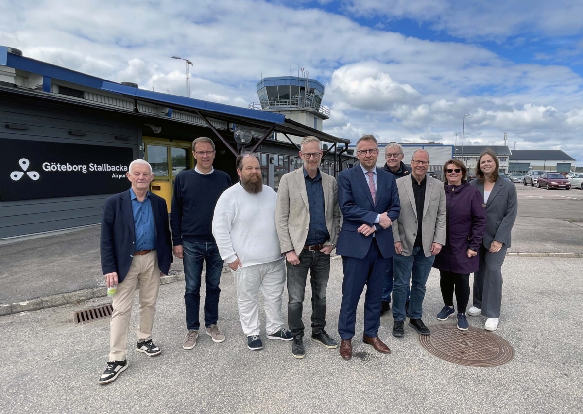 Gruppbild på styrelsen för Göteborg Stallbacka Airport. En grupp människor med flygplatsen i bakgrunden.