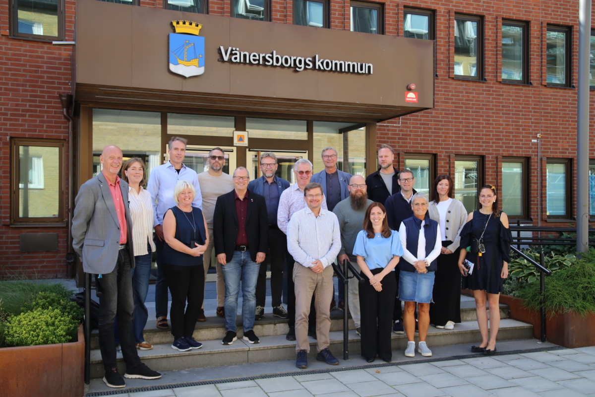 Gruppbild på flera personer framför entrén vid Vänersborgs kommunhus.